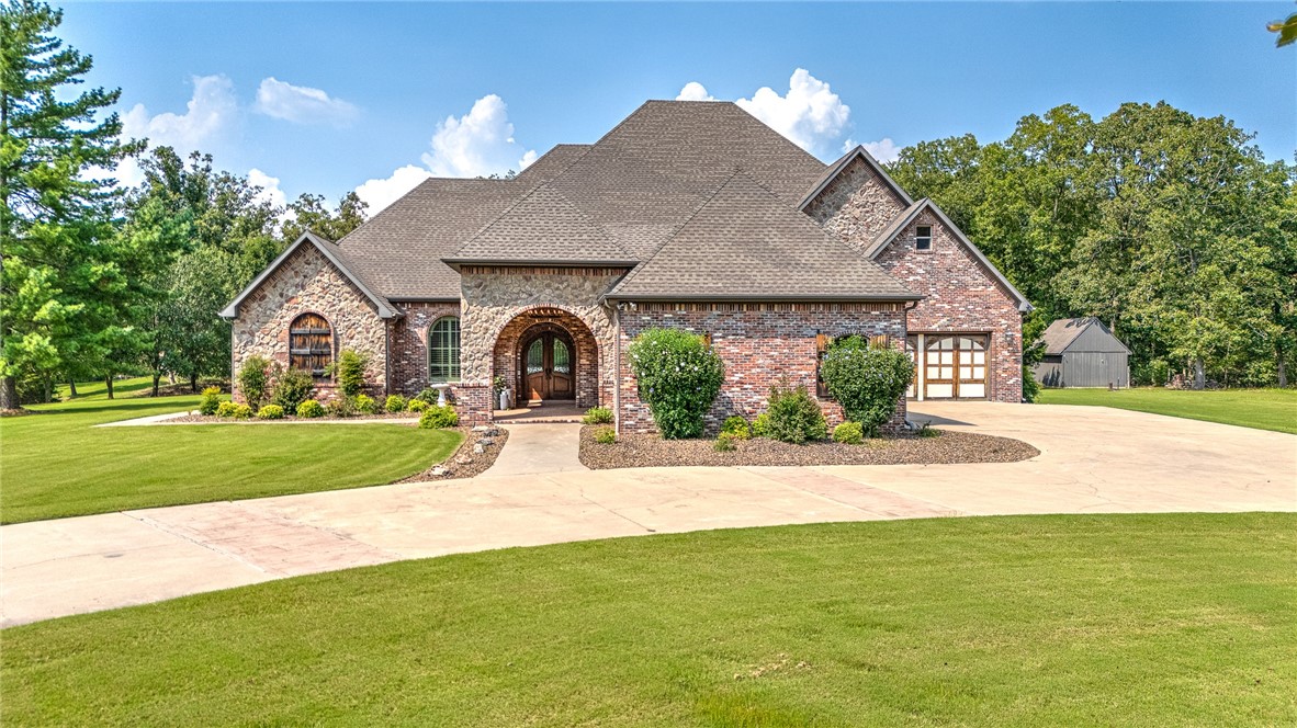 Stunning Estate home with Over 5+ acres in Bentonville Schools! Some of the special custom touches of this home include: Large custom Chef's kitchen, Ensuite Exercise room off primary bath, Safe room/large walk in closet, Each bedroom is a suite with a bathroom, Primary on main floor, Formal office space, Formal dining and eat in kitchen, Custom entertainment center and bar area in main Living, Large laundry and custom cabinets, Private patio/courtyard, deck off of main and upstairs living areas, new light fixtures through several areas, professional landscaping, irrigation system, New paint through several areas, large Bonus upstairs/mini bar area, landscaped and plenty of space for a pool, and exterior light system! With the bedroom suites, and multiple bathrooms, each space is thoughtfully executed to meet every need. Enjoy privacy with this estate lot, yet be less than 15 minutes to Downtown Bentonville and easy access to trails! New roof expected September 2024.