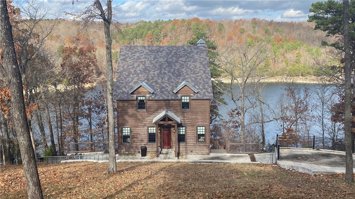 Coveted Lakefront Rustic Luxury! ONE-OF-A-KIND BEAVER LAKEFRONT Immaculate Chalet in a Quiet, Deep-Water Cove & LAKEVIEWS from Both Oversized Decks. Low Corp Line gives easy access to NEW RARE 4-Slip Private DOCK w/3 Lifts, Solar & Massive Swim Deck.  This 3-level Cabin boasts 4 BR, 3 BA, plus Loft with Built-in Beds that sleeps 9 & features Soaring Ceilings, Incredibly Unique Custom-Designed Details & Finishes thru-out by two local Designers/Artisans, down to the smallest details. Local NWA barn incorporated in home adds to its charm & character.  2 adj Lakefront Lots=1.09AC. Enclosed Outdoor Full Bath offers a quick access from Lake. Hobbs State Park-owned land across the water allows All Natural Views of Cove. This one is Truly a Secret Treasure in Desirable Location on the Lake!