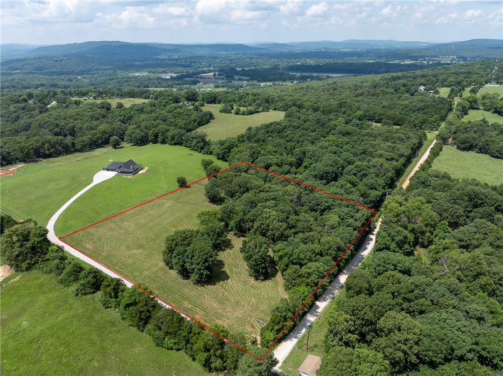 If you have been looking for land with character instead of completely flat, bare space - Here it is!  There's plenty of space to build and most of the land is level but there are trees, paths, a little sloping area and beautiful views to make your future home site a dream!  Gravel drive runs along one edge of the property, electric box already installed, and a recent perc test all make this an easy spot for your future build.  There are minimal covenants to protect the land value so let your imagination soar!