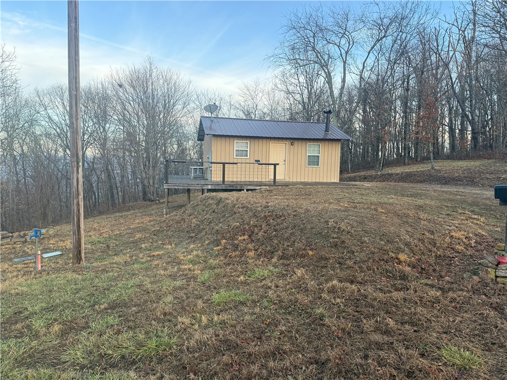 Escape to your own private Ozark retreat on this beautiful 9-acre property at 1613 Moonhull Rd, Oark, AR 72852. Bordering thousands of acres of National Forest in northern Johnson County, this land offers direct access to premier hunting, hiking, and trail riding right out your back door. The 384 sq ft all-metal cabin is fully furnished and move-in ready, featuring rustic sealed hardwood floors, custom hardwood cabinets, a cozy wood-burning stove, and a high-efficiency mini-split for year-round comfort. Utilities include electric, rural water, and high-speed internet, plus a 30-amp RV hookup for guests or future use. Located minutes from the Buffalo and Mulberry Rivers, Boxley Valley elk, and numerous hiking and riding trails—with Hawgsbill Crag just 30 minutes away—this property is surrounded by abundant wildlife and outdoor adventure. Its prime location also offers excellent short-term rental potential.