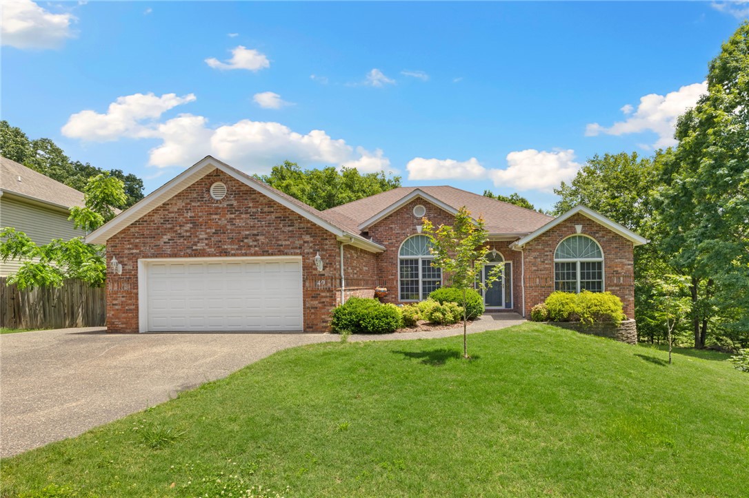 Located in one of Bella Vista’s most sought-after outdoor corridors, this home offers direct access to the Snowbird section of the Back 40 Trail system right behind the property. Serving as the ultimate launchpad for active living, you are minutes from the golf course, Razorback Greenway, and top-tier community amenities like a pool, playground, pickleball courts, and clubhouse.  The flexible floor plan features 3 main-level bedrooms, an eat-in kitchen, and a formal dining space easily utilized as a home office. Outside, a covered deck overlooks a large, flat backyard so you can sit and watch or heckle at all the golfers.  Surrounded by mature trees, offering serene wooded privacy, great curb appeal, and a peaceful, bike-friendly setting this home has it all!  Bonus: a finished workshop under the house provides the perfect space for bike tuning, gear storage, or hobbies. Direct trail access is just steps away!