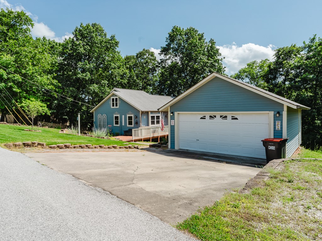 Enjoy nature with a bit of lake view just minutes from Hickory Creek Marina on Beaver Lake!  LOTS of possibilities with this!  Great square footage for this 3BR, 2BA, loft & versatile flex space on lower level.  Features approximately 1.46 acres, imported Spanish tile in LR with glass tile around the wood-burning fireplace, wood floor in kitchen & eat-in kitchen, Pergo plank flooring in loft, primary BR & walk-in closet. Enjoy your mornings & evenings on the upper or lower deck. A short drive to the water!  Front is nicely landscaped. New septic 2023, new roof & windows 2020, HVAC & water heater 10 years old, exterior has recent Behr stain, built-in book shelving added on lower level, faux wood blinds.