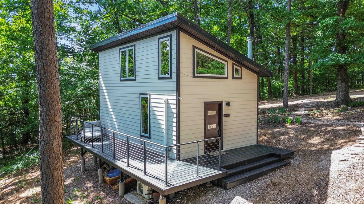 Imagine building your dream home on this amazing 8.66 acres of land in the Beaver Lake community of Northwest Arkansas. Built in 2024, the 1 bedroom/1 bathroom contemporary home is 624 sf with a loft and a viewing deck. Solid build with cement fiber board siding and a metal roof. Lots of windows for plenty of natural light and fresh air and a mini split for climate control and plumbed for a woodstove. Kitchen island is a new addition to be finished. The land is amazing and is covered with large, tall trees that are absolutely magnificent. Complete with a water well, septic system, electricity this property is situated on the east side of Beaver Lake and is the perfect setting for a homestead or recreational property. Enjoy all that Beaver Lake and Northwest Arkansas have to offer from this property. Live in it as is or during construction of a new main home and have a very nice guest quarters when your estate is complete. Come make this yours and join all the fun happening at Beaver Lake in Northwest Arkansas.