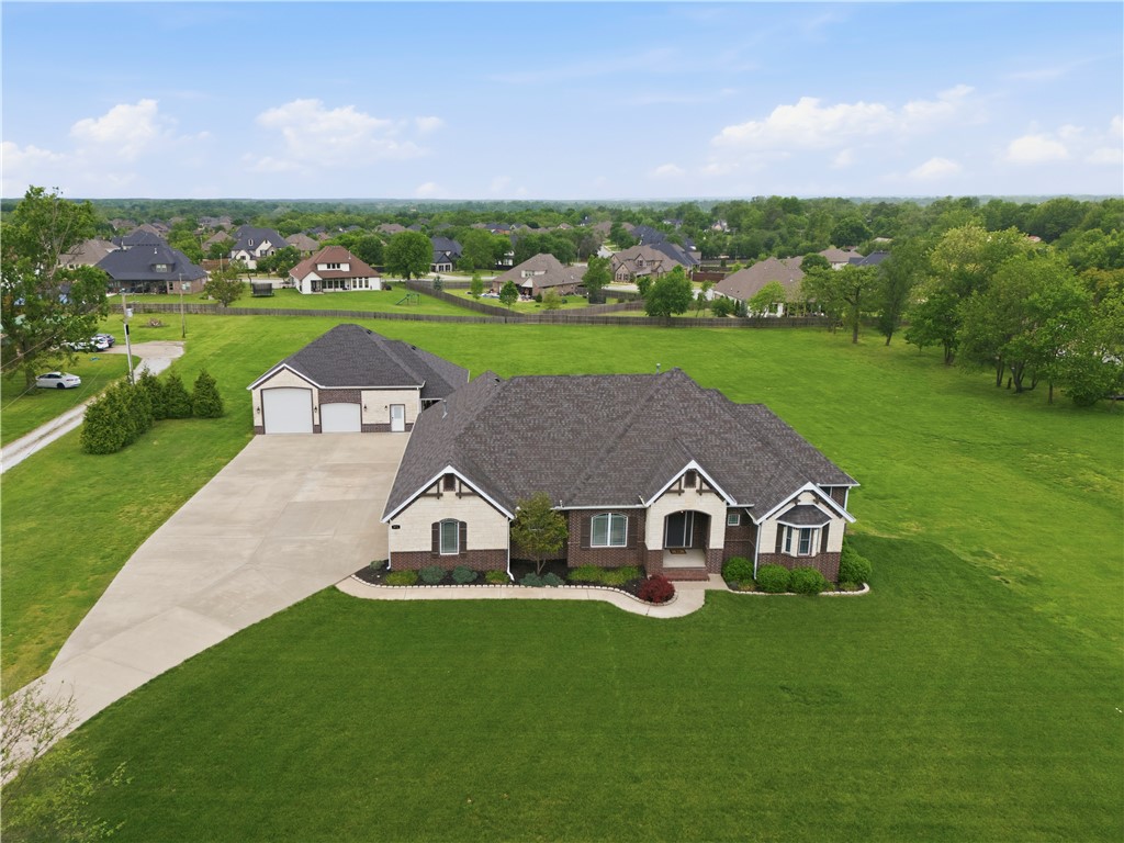 Experience refined elegance in this custom 3,295 sq ft estate, perfectly situated on 3 manicured acres in Cave Springs. Designed for elevated living, this property features durable architectural shingles, rich hardwood floors, premium granite countertops, an executive office, and a formal dining room. The thoughtful floor plan positions 3 bedrooms & 2.5 baths on the main level, while the second story hosts a private guest retreat with an additional bedroom & full bath. Indulge in the newly remodeled primary closet, boasting a boutique-style design with custom shelving & tailored organization. Reflecting the same exquisite elegance & quality of the main home, the secondary building offers a premium flex space with additional garage parking, a full bathroom, kitchenette, and entertainment room. Enjoy outdoor living with a private screened porch on the primary home and a covered porch on the secondary building. This premier location sits just 3 minutes from Mt Hebron Park and 7 minutes to vibrant Uptown Rogers & I-49.