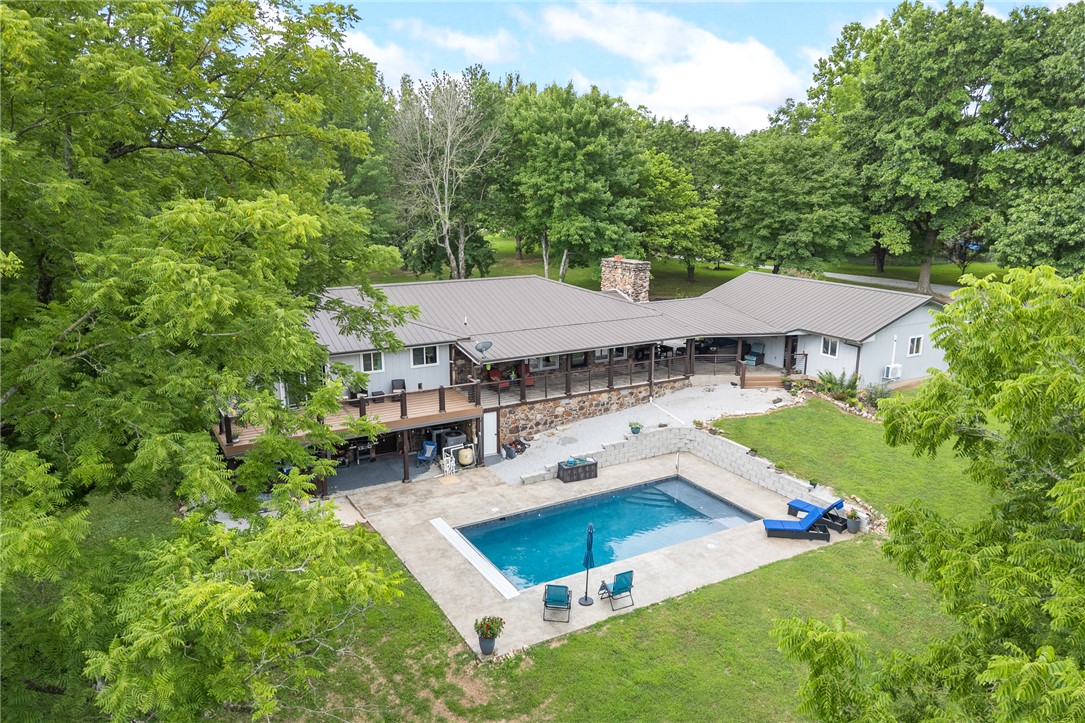Entertainer's dream on 2.75 private acres! This stunning 5-bedroom, 3-bath home offers the perfect combination of space, privacy, and exceptional outdoor living. The main level includes 3 bedrooms and 2 bathrooms, while the walkout basement offers 2 additional bedrooms, a full bath, and plenty of flexible space for guests, recreation, or a second living area. Step outside to your own private retreat. The massive covered back porch and patio overlook a heated and cooled saltwater Gunite pool with a retractable cover, installed in 2023, creating an incredible space for entertaining or relaxing. Whether you're hosting summer gatherings or enjoying a quiet evening by the pool, this backyard is ready for it all. The two-car garage has a workshop that provides plenty of room for vehicles, hobbies, and storage. Nestled on 2.75 secluded acres, you'll enjoy the privacy of a peaceful setting while being just minutes from town.