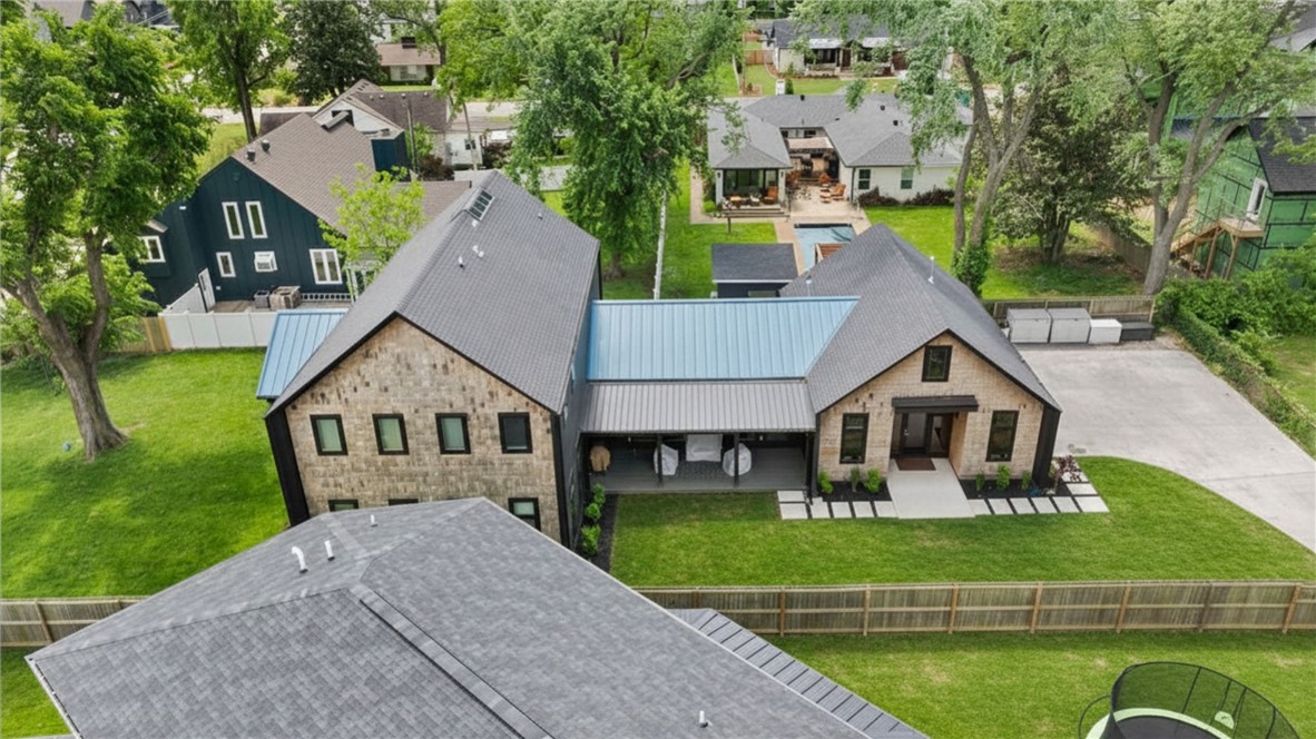 Luxury living in the heart of Bentonville at 715 NW 8th St—just 1 mile from Bentonville Square with quick access to dining, shopping & trails. Built in 2020, this 3,280 sqft home offers 4 beds, 3.5 baths, & a private flag pole-shaped lot. Vaulted living room with dual-sided windows and privacy tint fills the space with natural light. Chef’s kitchen features a large prep island & oversized pantry. Flexible bonus space off kitchen ideal for theater, or office leading to a fully enclosed sunroom. Enjoy outdoor living on the 26x8 covered porch with retractable screens. Main-level primary suite with spa-like bath & walk-in closet. Durable eucalyptus flooring & Anderson windows throughout. Upstairs includes loft/second living area, 3 bedrooms (1 with ensuite). Private yard offers space to design a custom outdoor retreat or pool—rare for newer construction so close to Downtown Bentonville. 3 schools within 1/2 mile. No POA, modern design, functional layout, turnkey, low-maintenance & move-in ready.