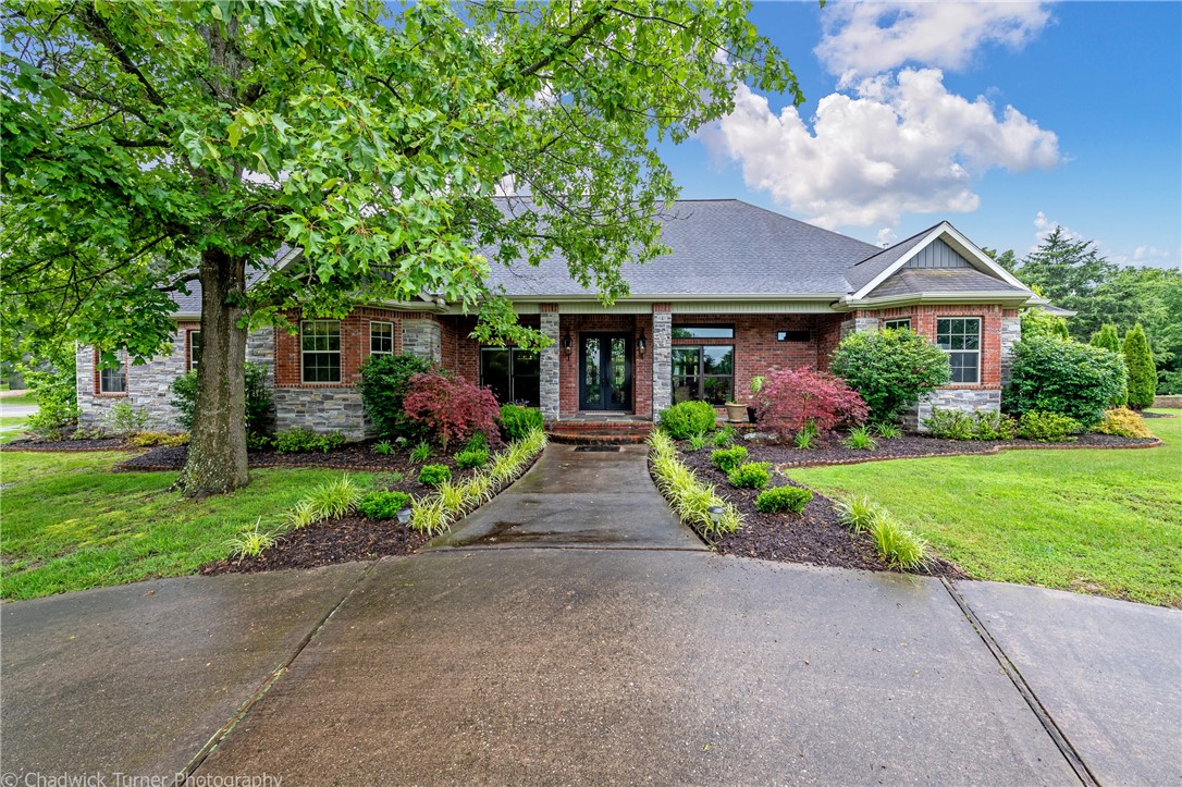 This 2004 story & half, full brick & stone, rustic & traditional styled home is privately situated on +/-11.65-acres, w/4-bedrooms, 3.5-baths, 3-car attached garage, landscaped front yard around house w/circle drive, 6-patios 2 covered, lily pad water feature area, fire pit area, grape vine pergola area, woodburner stove can heat house, partial fenced split post & raised garden bed boxes & 40x60 pole barn to house an RV or storage w/2 covered sides, entry foyer leads into massive living room w/gas fireplace, separate dining room, eat-in kitchen w/solid wood cabinets & Dekton Trilium counter tops, chefs work island, gas burner stove, commercial sized fridge & freezer, pantry, separate utility room between kitchen & garage, outdoor lounge off spacious master bedrm & bath suite w/two sinks, enormous shower, ladder walk-in closet & private access to hot tub & stone waterfall outdoor shower off master bath access, mostly all original systems in working condition & Seller offering Home Warranty w/acceptable offers.
