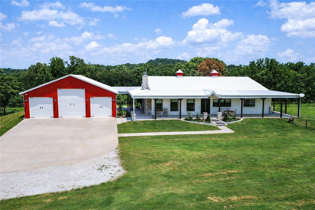 Welcome to your private country retreat—where modern farmhouse style meets comfort, functionality, and wide-open space. This thoughtfully designed home features a professional-grade Fisher & Paykel 5-burner range with griddle, perfect for the home chef, along with a FamilySAFE storm shelter for added peace of mind. Outdoor living shines with an expansive 1,786-SF covered patio overlooking a fully fenced 5,340-SF yard, ideal for entertaining, pets, or play. Exceptional outbuildings include a 1,480-SF detached garage with three drive-in doors and a 3,430-SF pole shed, offering endless storage, hobby, or workshop possibilities. Set on beautifully maintained acreage with panoramic views, wooded privacy, and a stocked 0.5-acre pond, this truly one-of-a-kind property delivers the perfect balance of luxury, utility, and serene country living.
