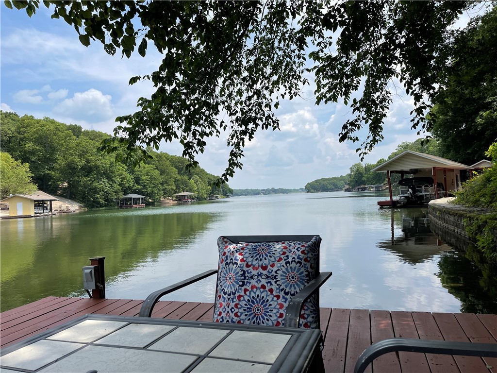 This immaculate and spacious Lake Loch Lomond home welcomes you to the wonders of lake living. Enjoy your peaceful shaded paved trail to the lake and your 48' x 19' dock with a 22'x11' boat slip complete with your pontoon boat that is included with the home. The perfect setup to enjoy lake living with family and friends. When not on the lake you will enjoy your multiple areas to relax with a large welcoming living room that leads to your beautiful sunroom. The spacious primary suite on the main level includes a fireplace and large bath with an oversized walk in shower. The main level features another bedroom, office, kitchen and dining. Downstairs enjoy a large family room with wet bar, bedroom, two huge storage rooms plus a big 23x19 workshop that has ac/heat. The lower level outside has a large covered patio to enjoy the view to the dock and lake. Video tour at https://vimeo.com/832390074  and matterport tour at https://my.matterport.com/show/?m=9hjYaE72goS&mls=1