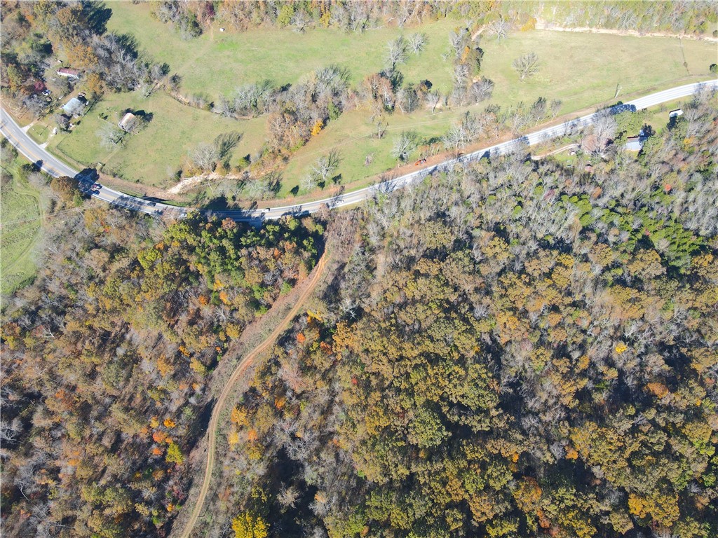 Set in the heart of the Ozarks, this 195-acre property offers a rare combination of accessibility, wildlife, and natural beauty. With direct frontage on U.S. Highway 412 and multiple gated access points, this land is as convenient as it is secluded.  A well-established internal road serves as the main artery through the property, providing easy access to numerous hunting stand locations and scenic vantage points. Two ponds add to the habitat mix and attract a variety of game.  Deer, turkey, and even black bear roam these woods, and it offers a truly fresh canvas for new management and infrastructure. With electricity already reaching the center of the tract, it’s suitable for a hunting camp, cabin site, or future home base.  The eastern portion carries an amazing mix of a large, relatively flat plateau paired with a beautifully rugged bluff.  The bluff can be easily descended in multiple places, depositing you onto yet another shelf, allowing for gorgeous hikes or hunting among house-size boulders and crevasses.