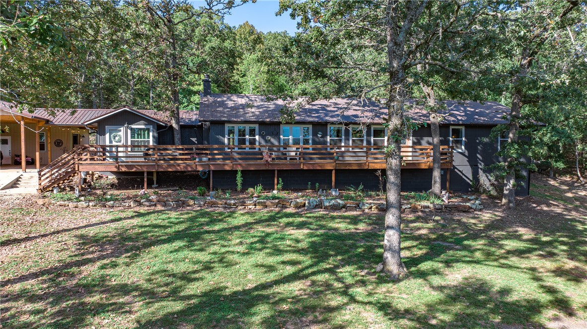 If you've been dreaming of wide-open space without sacrificing convenience, this is the one. Nestled at the end of a private drive on 5 park-like acres — half open, half wooded — this 4-bedroom, 3-bath ranch feels like a retreat, but sits just minutes from Fayetteville and Elkins schools. The open floor plan keeps everyday living easy, while the back patio and deck are made for the kind of slow mornings and easy evenings that remind you why you wanted land in the first place. A metal roof, propane range, built-ins, and a pantry mean the practical details are already handled. The attached workshop and 390 sq ft outbuilding give you room to work, store, or tinker. With 2,265 sq ft, a 3-car carport, and no flood zone concerns, this property checks every box — and then some.