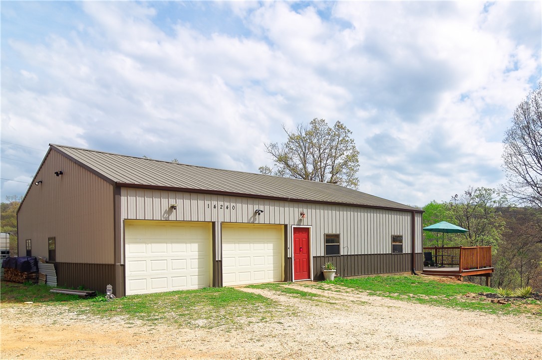 Scenic 30.4 acres with barndominium, shop & trails–Minutes to University of Arkansas. This versatile property features a well designed 2011 barndominium-perfect as a full-time residence, weekend retreat or temporary home while you build your dream house. Main living area offers approx. 1,052 sq. ft. with 2 br, 1 bath, full kitchen & laundry. Upstairs, a 418 sq. ft. loft studio includes a half bath-ideal for guests, home office or flex space. Spacious 959 sq. ft. attached shop--room for equipment, hobbies or storage. Numerous upgrades, including county water with culligan 3 filter system & reverse osmosis for kitchen sink & fridge, electrical improvements, ozarks go fiber optic & upgraded appliances. Outside, experience breathtaking views, abundant wildlife, wet weather creek & multiple trails. Recently surveyed, roughly 7 cleared acres & the rest wooded. Endless possibilities-hiking, exploring, soaking in nature. Priced below appraised value due to relocation. Great opportunity to own acreage in a desirable area.
