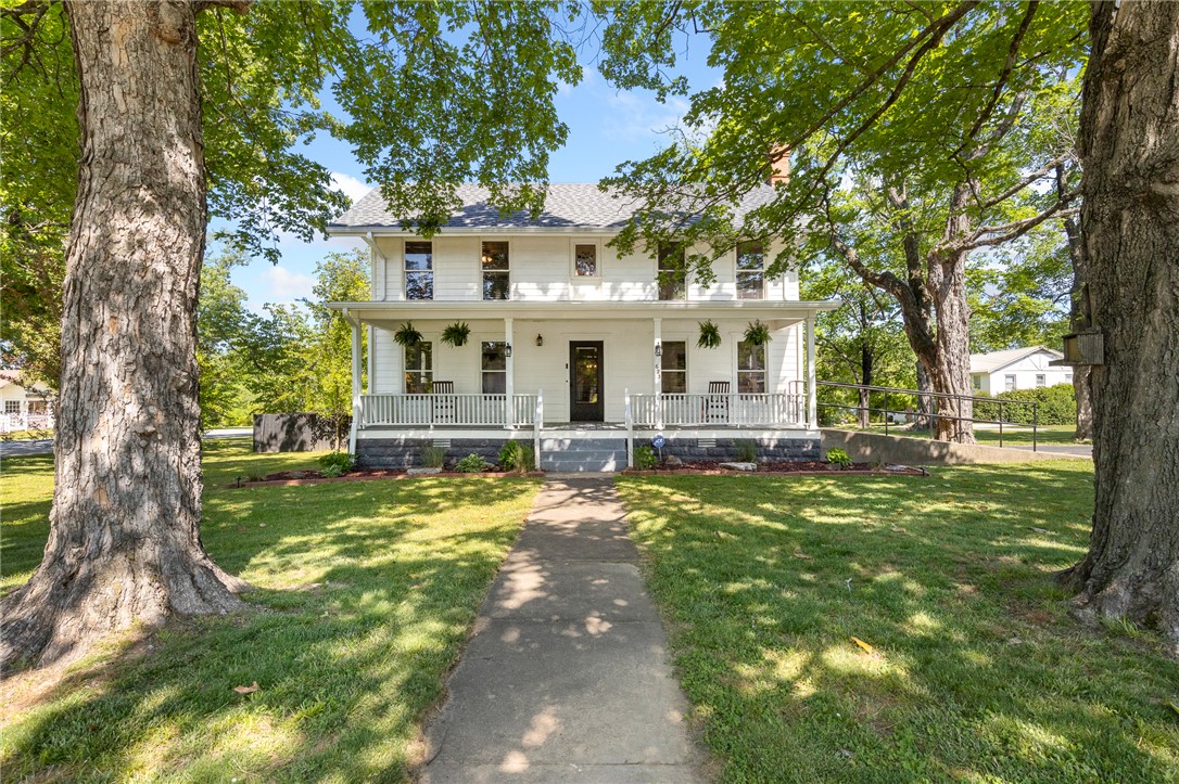 Built in 1898, The Capps House is a historic, iconic, masterpiece home in Harrison, AR!  The property and grounds have received many upgrades and restoration all while keeping its original charm and character.  Original hardwood flooring, claw foot tubs, the parlor room, gorgeous updated kitchen and all of the natural light that floods the entire home capturing her in the most beautiful light will be some of your favorite features.  Main level rooms:  primary bedroom, kitchen, utility, breakfast nook, formal dining, formal living, full bath and huge family room addition.  Upstairs features 3 bedrooms, 1 full bath and the parlor room surrounded by windows.  The covered front and side porches are to die for.  The grounds are manicured and landscaped with a fenced area for pets and a poured patio plus a one car garage and storm cellar.  New roof in 2025.