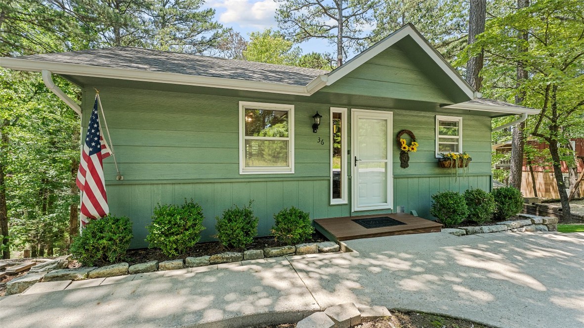 Charming and well-maintained Eureka Springs home situated on an approximately half-acre wooded lot with great privacy and a convenient location. Cared for by the original owner for the last 39 years, this home offers a warm and comfortable layout with vaulted ceilings, an open living/dining area, natural light, and inviting interior character throughout. Outside, enjoy a tiered landscaped yard that makes great use of the hillside setting, along with a detached storage building for added functionality. The wooded surroundings provide a peaceful Ozark feel while still being close to the heart of Eureka Springs, local dining, shopping, and area attractions. A clean, cared-for property with charm, privacy, and usable outdoor space.