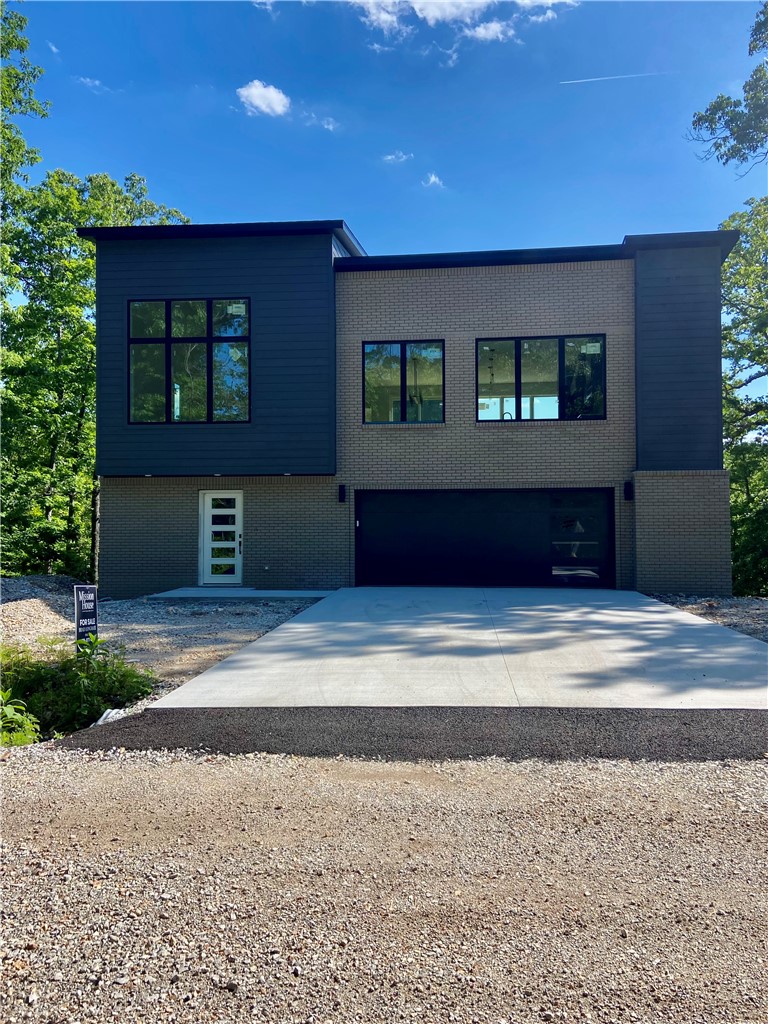 Surrounded by trees, this unique home offers a true “treehouse” feel with beautiful wooded views from expansive windows and abundant natural light. The open-concept main level features a spacious living area, oversized island, custom cabinetry, and a hidden/butler’s pantry—perfect for entertaining. The primary suite is a private retreat with serene views of the woods. The upper level includes the primary suite, kitchen, living area, and half bath, while the lower level offers two bedrooms connected by a Jack-and-Jill bathroom and a versatile flex space. Enjoy an oversized patio and a deck overlooking the woods, with no homes directly behind for added privacy. Located near the mountain biking trails and amenities that make Bella Vista so desirable, this one-of-a-kind home truly stands out.