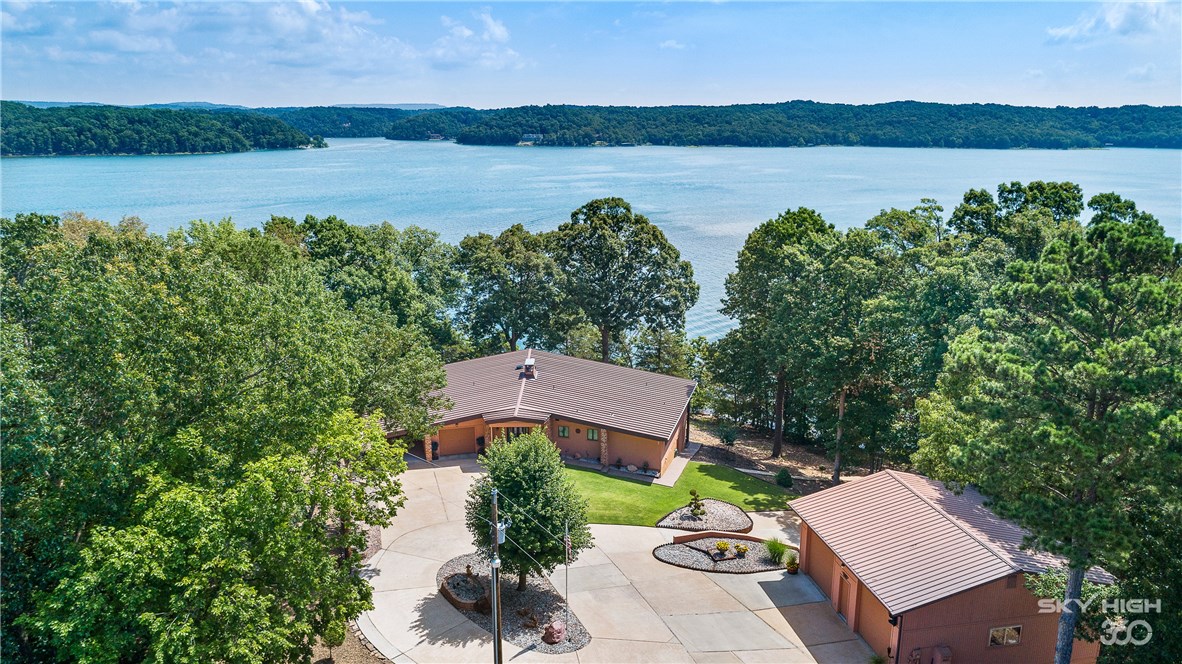 Magnificent gated custom lake home on .83 acre lot just at the water’s edge… Lush grounds & breathless views offer a private tranquil setting minutes from town. This exquisite home features 3 Bedrooms, 3 baths w/2 living areas and formal dining. Well thought out design for entertaining and featuring expansive decks with gorgeous views of Beaver Lake. One of a kind concrete constructed Carriage House w/2 main level bays & additional lower level bay for that hobby enthusiast. Step out your door & stroll to the family owned 3 slip boat dock w/swim deck, 3 lifts & electric.  Unsurpassed perfection with approximately 950 feet of shoreline that you will not find anywhere else! Call to schedule a private showing.
