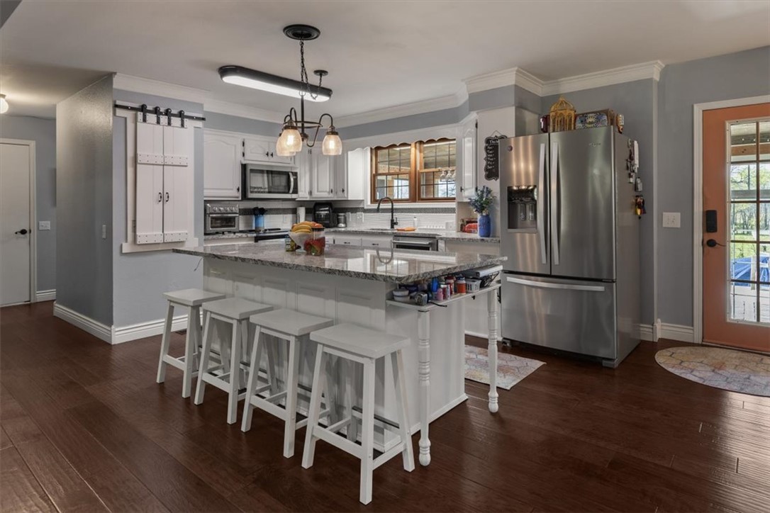 Discover the perfect blend of privacy, utility, and relaxation at 1111 Rocky Dell Rd NE! Situated on a sprawling 3-acre level lot in a prime Gravette location, this property offers a country feel lifestyle opportunity with room to breathe.
The heart of the home is the expansive owner’s suite, featuring access to the private indoor spa room complete with a hot tub. Office/flex space in the garage. Outside, the summer-ready backyard boasts a large above-ground pool, perfect for entertaining or enjoying quiet Ozark afternoons.
For the hobbyist or professional, the property includes a massive detached shop providing ample space for equipment, projects, or a home business. With three lush acres, there is plenty of room for gardening, animals, or future expansion, all while staying minutes away from downtown Gravette and NWA amenities. Whether you’re looking for a functional homestead or your own secluded spot near everything, this property delivers. House with 8.4 acres also listed for sale.