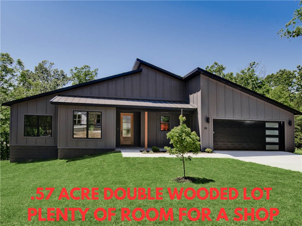 MOVE-IN READY! Stunning modern new construction home on a beautiful .57-acre wooded double lot with plenty of room for a future workshop. This home offers easy access to I-49, Lake Loch Lomond, nearby trails, and Highlands Golf Course. Featuring 3 spacious bedrooms plus an office, this residence showcases tall modern ceilings that enhance the open feel. You will love the large waterfall kitchen island, complemented by a gas range and a huge pantry. Experience the benefits of a split floor plan for added privacy. Step outside to your oversized covered patio, ideal for entertaining or relaxing in the serene surroundings. Custom finishes throughout. Plus, take advantage of $3,500 in buyers closing costs, courtesy of the builder's preferred lender!