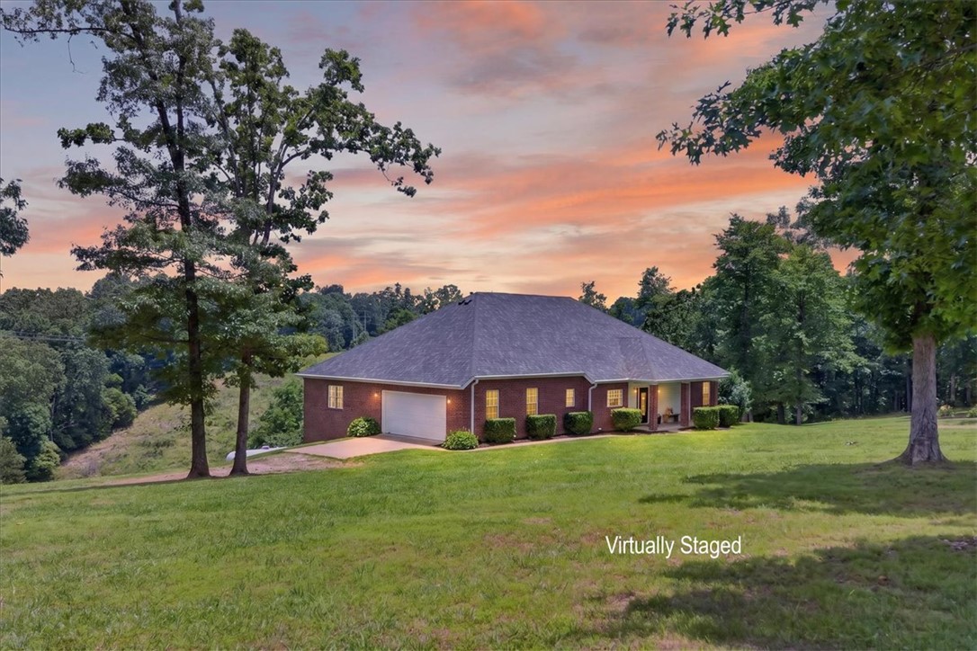 Perched on a scenic Ozark ridge, this remarkable 5-bedroom, 5-bath home offers something increasingly hard to find: space, privacy, & views that stretch for miles! Close your eyes & envision the hustle of the day fading away; replaced by rolling valley vistas, mature trees & forests, & the peaceful beauty of countryside.
The elevated terrain of this 5.08 acres creates a private hillside retreat where the landscape delivers breathtaking views, natural privacy, & a sense of seclusion that flat acreage simply can't replicate. Here, you'll spend less time maintaining land & more time enjoying it.
Built in 2008 & thoughtfully updated with a new roof & HVAC system in 2023, this solidly constructed home offers over 4,500 square feet of flexible living space designed for both everyday comfort & memorable gatherings. The main level welcomes you with a layout that flows effortlessly from room to room, creating the perfect backdrop for holiday celebrations, family dinners, or quiet evenings overlooking the valley.