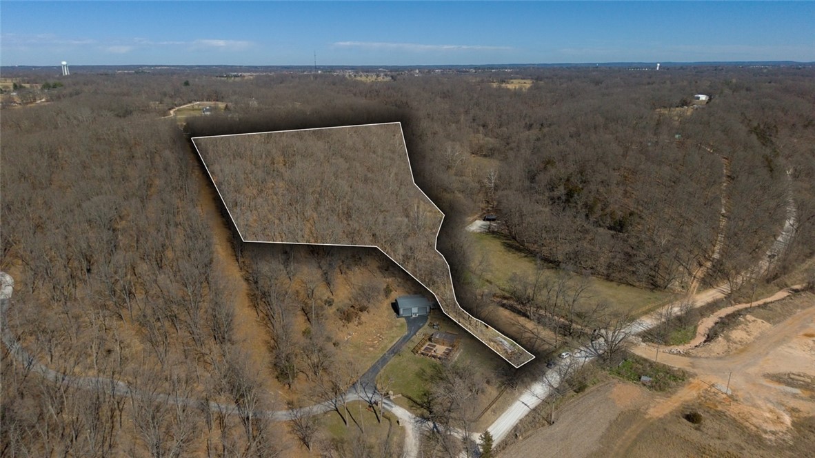 Don’t miss the opportunity to secure 5 acres with privacy and long-term potential just minutes from Downtown Bentonville. A private drive leads to a level homesite, offering a quiet setting with flexibility for a custom build.

The acreage is usable and build-ready, with a private well already in place. Whether you’re designing a modern estate, a walk-out layout, or simply looking for space close to town, this property provides room to create without sacrificing convenience.

Located just 6 miles (approximately 12 minutes) from downtown Bentonville, you’ll enjoy a rural feel with quick access to trails, dining, and daily amenities. Hard-to-find acreage in a high-growth corridor with strong future upside.
