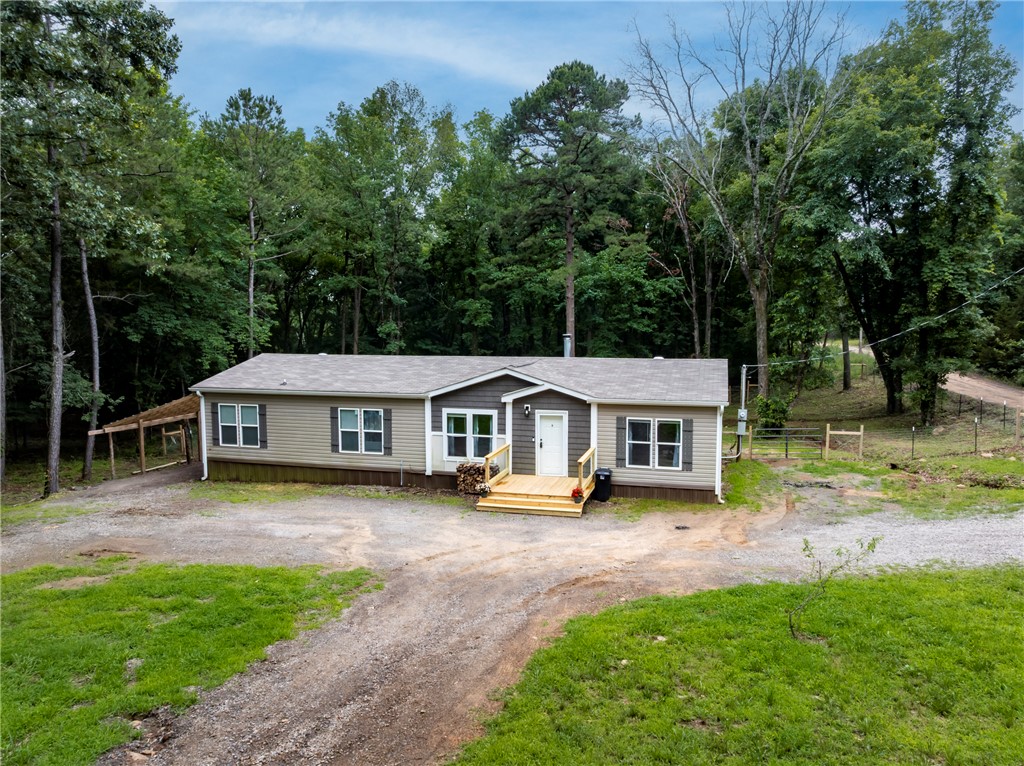 Immaculately maintained 3-bed 2-bath, 1568 sqft home on 5.08 acres, permanently affixed, eligible for FHA,VA,USDA/RD and conventional loans. Features: custom closets and pantry shelving(2024), new decks front and back, fencing, lean to posts, gravel all done May 2026, gutters(2025 cleaned every 3 months). 2 working wells (filters changed every 3 months), natural spring on the property along with peach trees. Inside: wood laminate flooring in the main areas, split floor plan, large kitchen island, soaking tub, and tiled walk-in shower. HVAC coils cleaned inside and out(2025), monthly filter changes. RV hookup with it's own electrical panel box. Ecobee programable thermostat, propane line added for optional gas stove. $2000 lender credit with First Colony. Plus hunt in your own back yard!