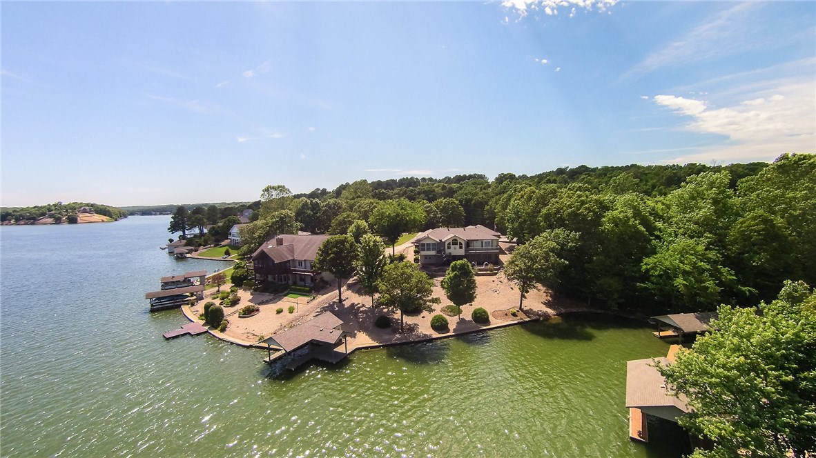 Vacation all year! Quality built Lake Lomond lakefront home with level drive & easy access to water's edge & boat dock w/lift. 158' of shoreline & fantastic views to enjoy from home, sunroom or screened in patio. RV parking w/ 30 AMP service. Family room has wet bar, large unfinished storage or workshop in basement. Geothermal HVAC. Sunroom has air only & is not included in S.F. Awesome outdoor space, upper level deck with panoramic views & lower level screened patio + covered patio. Enjoy one of the best views of Bella Vista's July 3rd fireworks celebration! You will see it all! Your friends & family will look forward to being your guest!