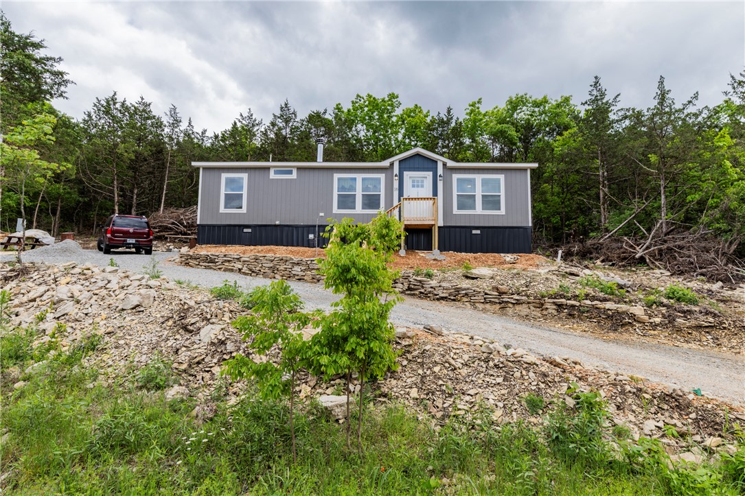 Built in 2025, this like-new manufactured home on a permanent foundation sits on a quiet cul-de-sac in Holiday Island on the high side of the street with scenic views. Bright windows filled the home with natural light and showcase frequent wildlife sightings including deer, birds, and squirrels. Enjoy a peaceful setting just minutes from golf, the marina, Table Rock Lake and amenities.