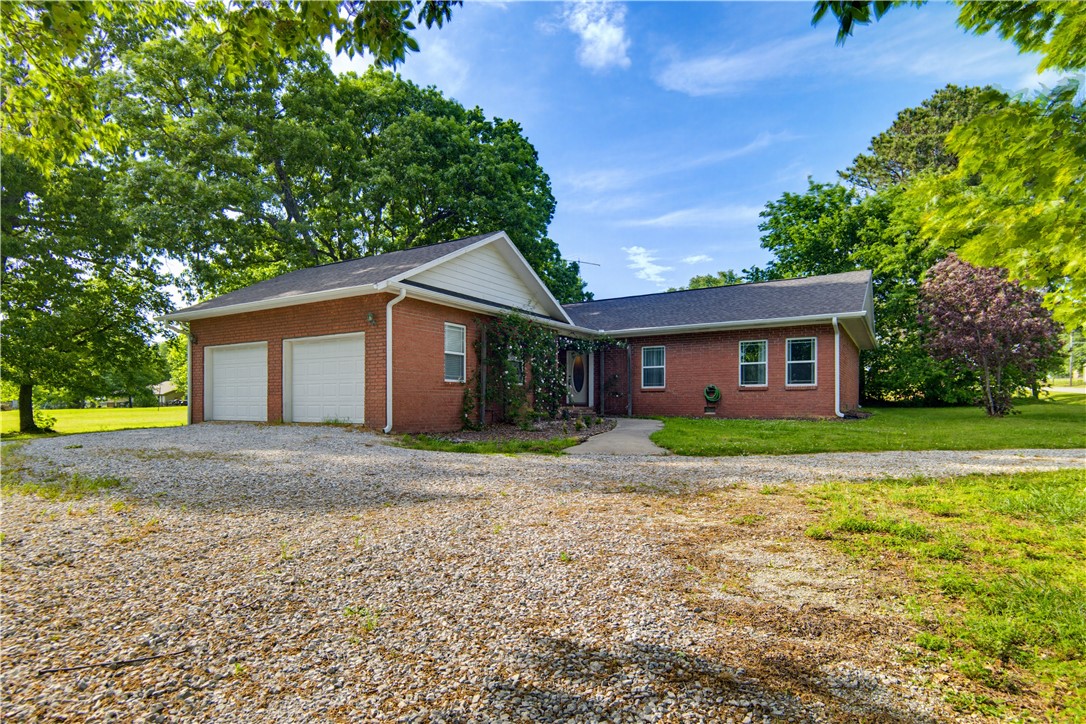 Nestled on a peaceful half-acre lot, this beautifully maintained 4-bedroom, 2-bath ranch-style home offers space, comfort, and convenience just minutes from I-49. Inside, a seamless open floor plan is highlighted by rich hardwood floors and a charming exposed brick accent wall in the living room, adding warmth and character. The updated kitchen features stainless steel appliances, gas range, ample cabinetry, and a spacious pantry, making it both functional and welcoming. Step outside to an oversized deck overlooking the private backyard, perfect for entertaining or relaxing outdoors. With a two-car attached garage, additional storage building, and easy access to shopping, dining, and everyday amenities, this property delivers the perfect blend of quiet living and modern convenience. Ask about the amazing preferred lender credit!