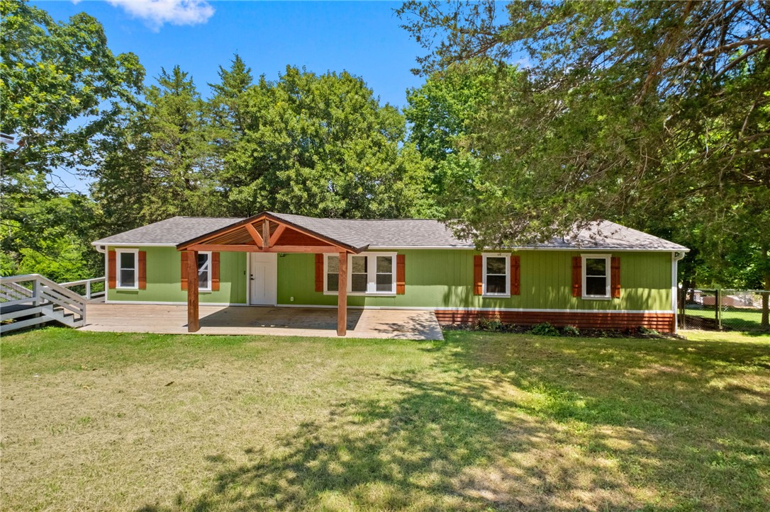 Located near Beaver Lake, this four bedroom, two bathroom home offers a spacious split floor plan with comfortable living areas and thoughtful updates throughout. The kitchen includes a large walk in pantry, while the primary suite features a generous closet and a distinctive barn door accent leading into the bathroom. Recent improvements include a new roof, new HVAC system, lifetime gutters, added exterior stairs, and a drain installed near the garage to improve water flow. The fenced backyard provides added privacy and space to enjoy the outdoors, along with a large back deck that is well suited for relaxing or entertaining. A welcoming cedar beam front porch, durable flooring, ample storage, and a practical layout complete this well maintained home.