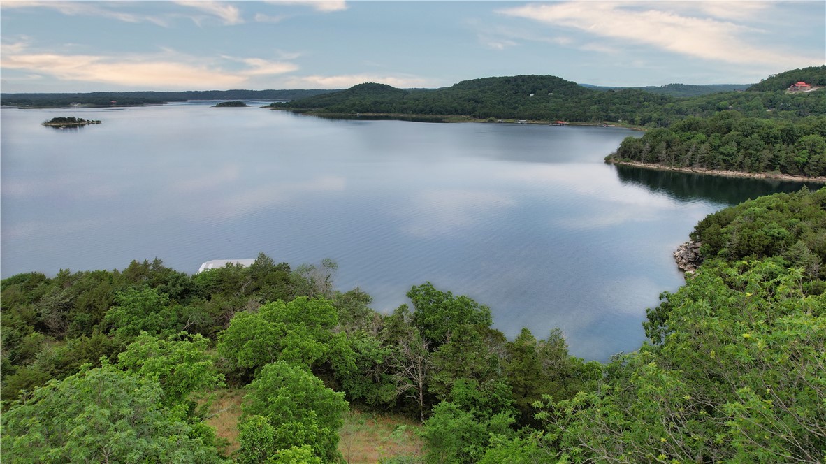 Escape to the natural beauty of Beaver Lake with this rare +/- 6.5 acre property tucked away in the peaceful hills of Garfield, Arkansas with approximately 420' of shoreline. Featuring a coveted boat slip, private well, septic system, and electric already on site, this property is ready for your dream lake retreat, vacation getaway, or future custom home. Surrounded by mature trees and abundant wildlife, you’ll enjoy privacy, serenity, and easy access to the sparkling waters of Beaver Lake. Whether you’re looking for a weekend escape, investment opportunity, or the perfect spot to build, this property offers the ideal combination of acreage, utilities, and lake lifestyle. Conveniently located near Rocky Branch Marina by boat, hiking trails, and outdoor recreation, this is your chance to own a slice of Northwest Arkansas lake property. Property has electric on site, well on site, and septic on site. Property currently has unlivable mobile home on site. Just in time for you to enjoy this year's lake season!