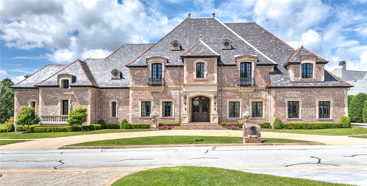Exceptional and timeless French and Swiss influenced Manor built upon a one-half acre site boasting AMAZING views in all directions with multiple balconies and verandas overlooking the 12th, 14th, and signature 15th island holes of the prestigious Pinnacle Country Club. Constructed of concrete and steel, this energy efficient estate was built to endure generations to come and features 10,341 sq ft of living space. From the aged travertine and hand scraped wooden floors to the handmade interior doors and imported slate roof, this spectacular estate stays true to the Old World style and evokes a sense of grandeur with a warm and inviting touch! Arranged over 4 floors featuring 5 bedrooms, 5 full & 2 half baths and luxurious rooms perfect for entertaining including a library, exercise room, & full media room. Almost 2,000 sq ft of unfinished walk-out basement space offers a blank slate with great possibilities. Just minutes from high-end retail, restaurants, Walmart AMP, Top Golf, medical facilities, and I-49!