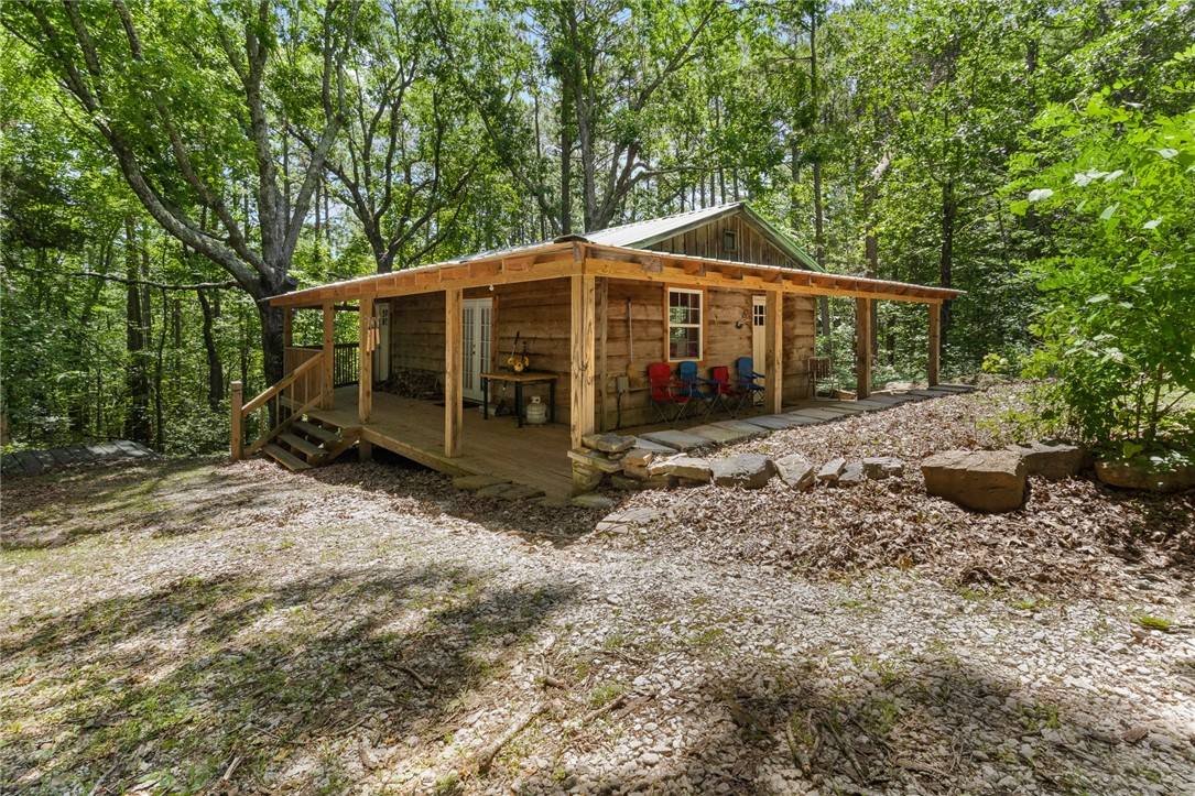 Looking for Seclusion, Privacy, and Peaceful Living? This could be your place. 3 homes in one with 29 acres and 2 ponds. First cabin is a one-bedroom, one-bath, and a living room. Next to this is the Earth Home that features 3 bedrooms, 1 bath, 2 living rooms with 2 fireplaces, and several outbuildings. The second cabin has a separate driveway but is within walking distance to the first cabin and the Earth home. This cabin has a wrap-around porch, 2 bedrooms, 1.5 bathrooms, a living room, and a kitchen. 2 cabins come fully furnished. The large pond is stocked with lots of fish, 2nd pond is spring-fed. SOLD AS IS! Potential for a VRBO and close to the Buffalo River.