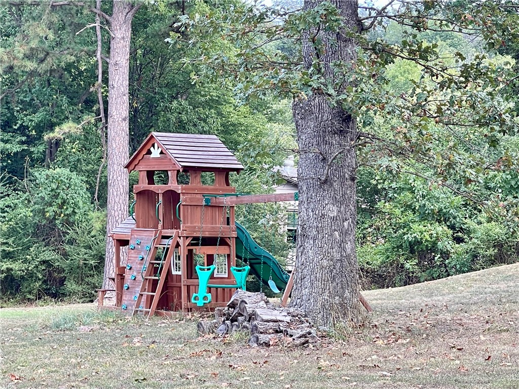 This 4 acre property presents a rare opportunity to own more than a small lot within the city limits, boasting a picturesque park-like setting and effortless access to local amenities. The 2-bedroom, 2-bathroom residence (3rd bed poss w/armoire) offers 1680 sq ft of living space, office/flex room off the kitchen, further enhanced by a spacious 288 sq ft screened porch/sunroom in the front entrance of the home. A separate 10x16 building provides versatility for use as an art studio, office, or guest room.Ample storage space is available in the garage. This home showcases character and charm, set amidst a serene 4-acre backdrop within the city limits.With convenient access to Hwy 412, discover NW AR's comprehensive trail network featuring biking, hiking, and mountain biking trails.Enjoy a variety of outdoor pursuits, including camping, fishing, and water sports, with easy access to Beaver Lake, War Eagle Creek, and the Buffalo National River. Utility availability is the responsibility of the buyer or buyers agent.