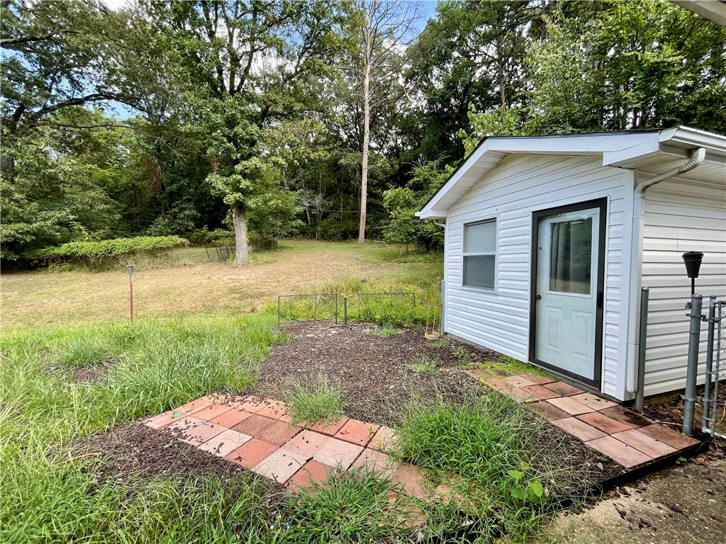 This 4 acre property presents a rare opportunity to own more than a small lot within the city limits, boasting a picturesque park-like setting and effortless access to local amenities. The 2-bedroom, 2-bathroom residence (3rd bed poss w/armoire) offers 1680 sq ft of living space, office/flex room off the kitchen, further enhanced by a spacious 288 sq ft screened porch/sunroom in the front entrance of the home. A separate 10x16 building provides versatility for use as an art studio, office, or guest room.Ample storage space is available in the garage. This home showcases character and charm, set amidst a serene 4-acre backdrop within the city limits.With convenient access to Hwy 412, discover NW AR's comprehensive trail network featuring biking, hiking, and mountain biking trails.Enjoy a variety of outdoor pursuits, including camping, fishing, and water sports, with easy access to Beaver Lake, War Eagle Creek, and the Buffalo National River. Utility availability is the responsibility of the buyer or buyers agent.