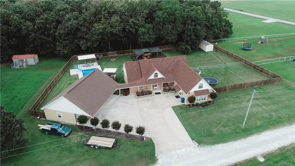 Well built 2006 3-bed, 2-bth, 2,789sqft home on a flat acre with a wonderful eat-in kitchen, formal dining area, bonus room over the old garage now converted to multi-office space off laundry room with exterior access,  great backyard with heated in-ground pool, fire-pit area, hot tub area, kids play gym, separate pet fenced area & fully fenced, 3-car carport in front of 3-car detached 23x42 garage, covered walkway to enter main house.  This compound could be yours ready to move in & call home!
