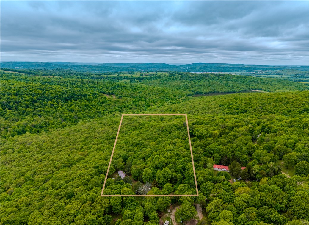 Opportunity meets acreage just outside Fayetteville. This 5-acre parcel offers a blend of privacy, usability, and flexibility with approximately 4 wooded acres and 1 cleared acre already in place. Utilities include water, electric, and existing septic, providing a strong head start for future plans. Manufactured homes are permitted, making this an excellent option for a primary residence, investment hold, or new homesite with room to spread out. Tucked in a peaceful setting with convenient access to Fayetteville amenities while still enjoying the feel of country living. Located in the Greenland School District. Hard-to-find small acreage with utilities already on site and multiple possibilities. Uninhabitable structure and personal property remain on site; buyer to verify condition/removal.