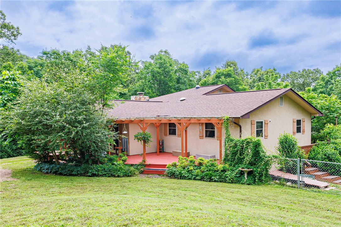 Three miles from town, a world away from the noise. This 3-bed, 2-bath home sits on a peaceful Flippin-area road with a wraparound porch,pear, peach, apple, and American chestnut trees, persimmons and grapes, a fenced garden, and landscaping that gives you something worthstepping outside for in every season. The enclosed sunroom with hot tub and pergola deck do the rest. Inside, geothermal heating, a whole-house generator, a water purification system, an attached garage, and a wood-burning stove with a gas stove option already in place. Outside, a23'x24' detached garage, 30'x17' workshop, and 19'x15' wood shed. The White River is minutes away. Close to everything. Feels like none of it.