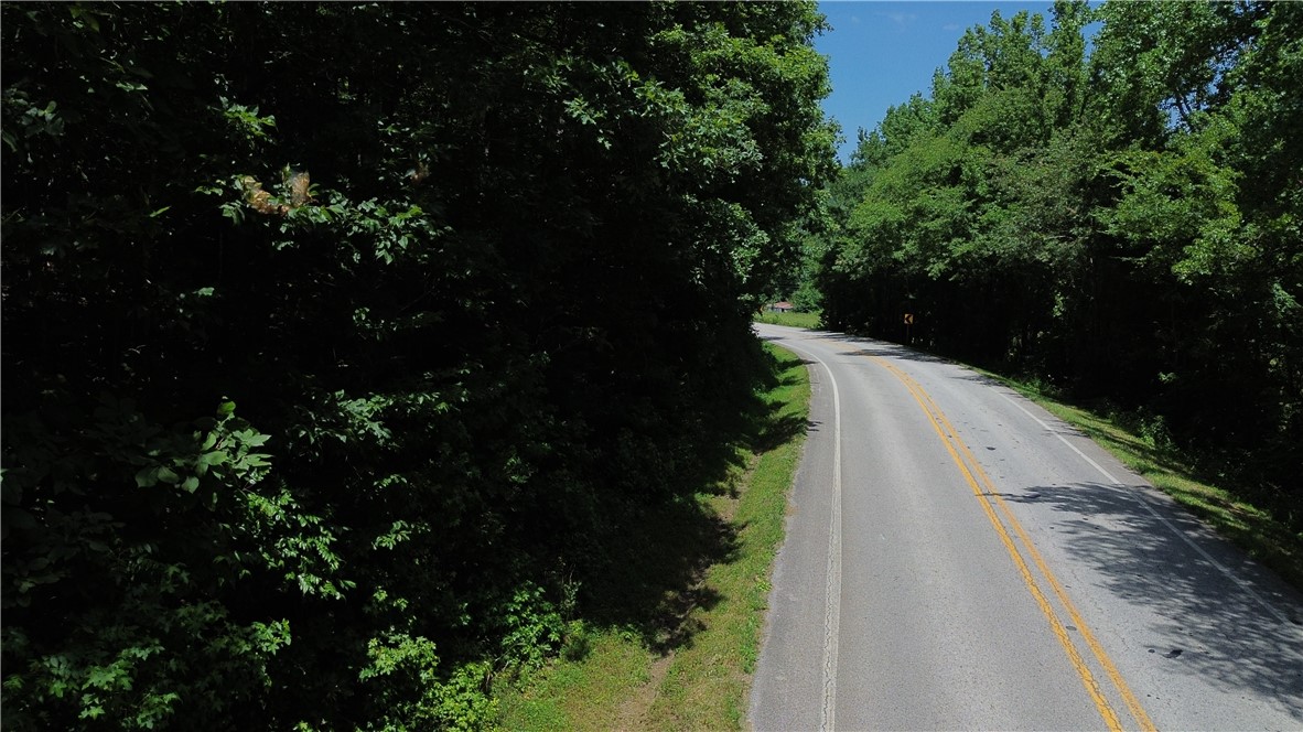 7 +/- unrestricted wooded acres with frontage on scenic Highway 23 (Pig Trail Scenic Byway) just south of Combs. This beautiful tract also features dirt road frontage along the back of the property, offering multiple access points and flexibility for future development. With electric available at the road and no restrictions, it's ready for your dream home, cabin, or recreational getaway. Selective clearing could reveal stunning Ozark Mountain views, creating an incredible homesite. The property is loaded with deer and other wildlife sign, making it an excellent hunting or nature retreat. Enjoy the perfect balance of privacy and convenience with easy access to Fayetteville while experiencing the beauty and tranquility of the Ozarks. A rare opportunity to own a versatile piece of Northwest Arkansas land.