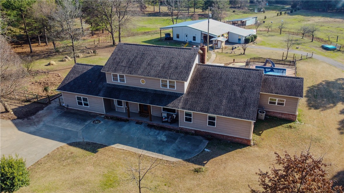 This beautiful 20+/- acre hobby farm is full of charm with over 3,200 square feet of living space. There are 2 master suites, giving you lots of options for family or guests. The kitchen is well thought out with a country-style design that fits the setting just right. The lower master suite is especially roomy and comfortable, perfect for relaxing after a long day. Out back, there’s a screened-in porch where you can sit and enjoy the breeze. The swimming pool adds a nice touch for cooling off in the summer. The land is fenced and cross-fenced, great for horses or cattle. There’s a pond on the property that’s both pretty to look at and useful for livestock or fishing. There's also a big shop building that's heated and cooled, complete with its own office and plumbing—perfect for a home business or just working on projects. You’ll also find a separate studio guest cottage on the property with a full bathroom.