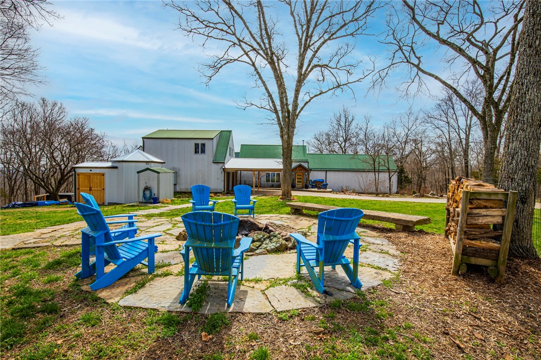 427 Beautiful acres offers a special kind of privacy while only being 25 minutes from Rogers and 9 minutes to Beaver Lake. The 4477 Sq. Ft. home sits 1/2 mile down a concrete driveway and was built in 1996 but has been completely remodeled with high-end upgrades to include: Granite countertops, custom walnut cabinets, hardwood floors, high efficiency wood burning fireplace, heated floor in master bath with steam shower, double oven, thermador appliances, tornado shelter/safe room, propane powered generator, hot tub, and much more. The custom home has 4 bedrooms, 4 bathrooms, 1 half bath, 1 office. The main house has an attached 2 car garage and another detached 2 car garage/workshop sits just to the north a short distance. Above the detached garage is an additional 736 Sq. Ft. living quarters that is fully functional with a kitchenette and full bath. The property includes: Professional landscaping with rock work, 12'x20' green house, garden area, 12'x12' dog house, fire pit, hot tub and propane generator.