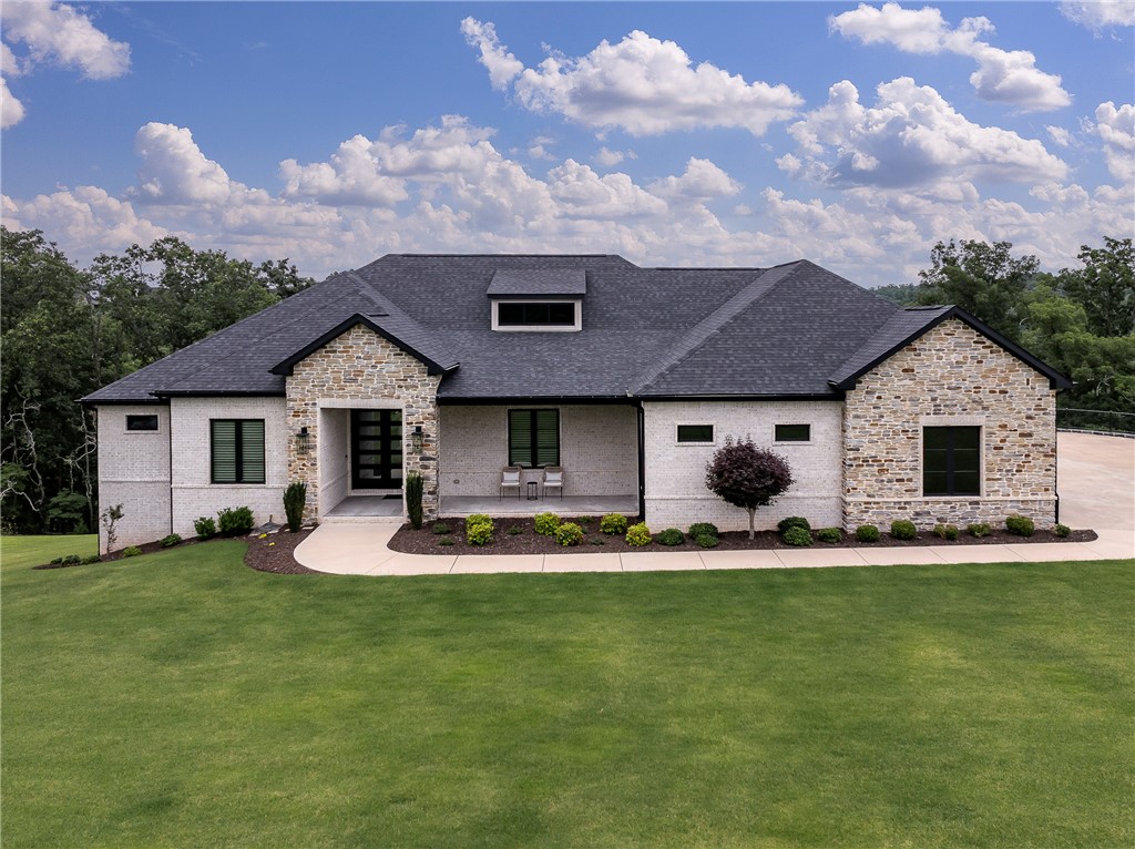 Your Luxury Beaver Lake lifestyle begins here! Tucked inside the prestigious gated Estates of Lakeway, this exceptional 3,924 sq ft retreat is just steps from your 10' x 26' boat slip & 10 minutes to town. Designed for effortless living, the open floor plan offers two private levels w 5 bedrooms, 3 full & 2 half baths, 2 living rooms and 1176 sq ft of storage. A level entrance leads you into the great room w floor to ceiling windows revealing the gorgeous tree lined view & beautiful porcelain tiled gas fireplace.  The great room flows seamlessly into the chef's kitchen marble & quartz countertops, dining area & two Trex decks, one screened. The walkout lower level features a kitchenette, game/media room, 2 bedrooms, 1.5 baths & 1166 sq ft w unfinished shop & storage for your lake toys. A rare 4-car garage w a 33'x10'x9' bay for boat or trailer storage, luxury finishes, hardwood floors & remote shades complete this resort like retreat. This is a rare opportunity to own a turnkey luxury retreat on Beaver Lake!