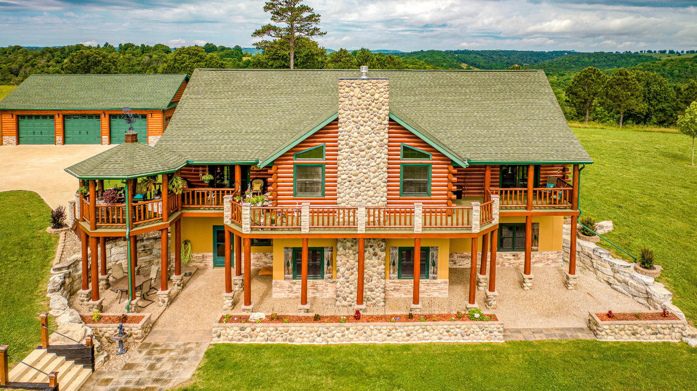 Enjoy the lake view from these 50+ gently  rolling acres. Custom built 4 Bedroom 3.5 bath log-sided home. Over 4500 square feet of quality, precision workmanship. Solid oak doors, trim, and cabinets. Beautiful rock fireplace with gas igniter on both levels, There are two bedrooms on the upper level and two on the lower level. Lower level also has a full kitchen and a walkout entry for easy access. R19 insulated walls, R50 in attic. Hurricane ties, 200 amp service, surge & lightning protection. Two stage a/c, Fiber optic internet, TV antenna, Argon filled windows, upgraded laminate flooring. Built in medicine cabinets and Kohler showers w/ lifetime warranty, Gourmet Kitchen, 12x12 gazebo. Landscaped ,custom rock flower boxes, and lighted yard. 30x40 detached, insulated 3 car log garage, 2 sheds, pole barn, boat/trailer shelter. 2 Bd. mobile rents for $450. 36 miles to Branson, 45 min. to Buffalo River, 5 miles