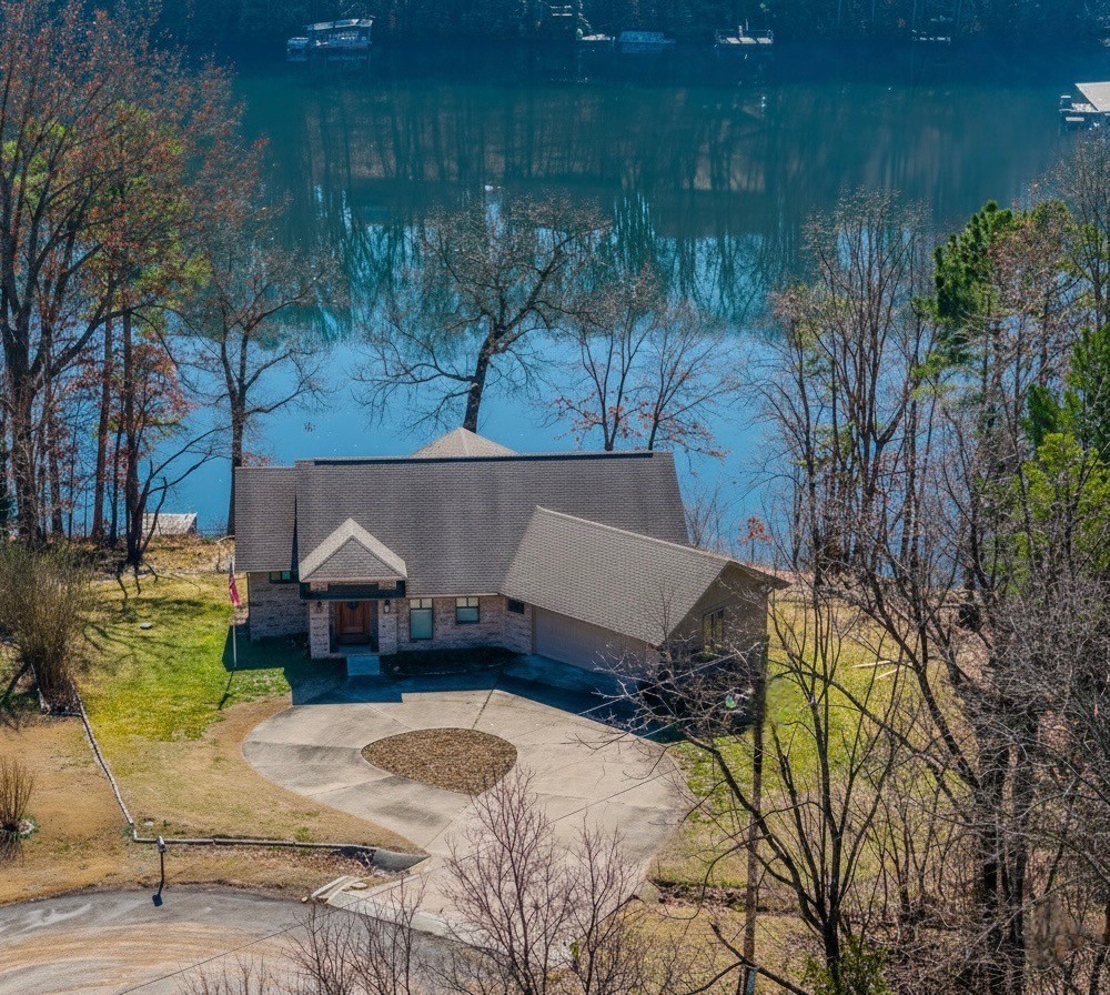 Experience stunning lakefront living on Lake Ann in this rare, private retreat in Bella Vista, with only 1 neighbor! The moment you walk in, you’re greeted by breathtaking, panoramic water views framed by floor to ceiling Anderson windows & soaring vaulted ceilings.  Main level was completely remodeled in '21, boasts a custom open concept kitchen & living/dining area for both entertaining & everyday comfort. It has the primary bed/bath, second bed & office space.  Lower level walk-out with a kitchen, living room, bed/bath, office & tons of storage, perfect for Air BNB/rental or mulit-generational living! With a prime location, situated at the end of a cul-de-sac & IMMEDEDIATE ACCESS TO THE BACK 40 & PINION FALLS!  You are only a quick 10 minute drive to the new OZ Bike Lift & 20 minutes to the Walmart Campus. Do not miss out on this purely Bella Vista lifestyle home with lakeside yard & easy access to your private swim dock for years of family fun! Enter circular drive slowly  large speed bump at top of driveway!