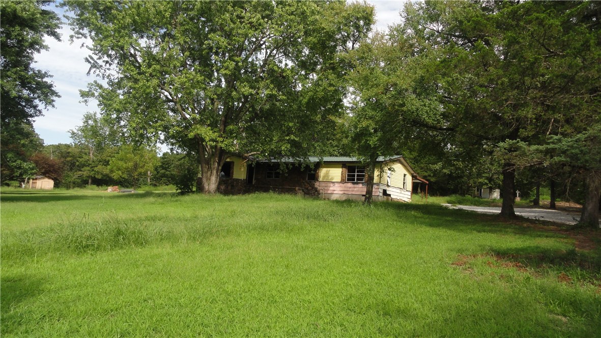 Large home & large concrete shop on 1.5 acres Hwy 265. House & shop sold "as is". Fixer upper. Greenland schools. Great location. Agent owned