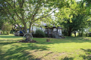 Country farm house on 5 ac w/stocked pond, barn, coral and approx. 4 ac of fenced pasture.  This home sits just off a state Hwy in the country. Metal roof and vinyl siding for low maintenance.  Plenty of room to have a garden and a few farm animals.  Country charm with original shiplap walls and cedar accents.  Large kitchen/dining room combo that opens to the living room.  Storm shelter and garage/shop building for the projects.  Only 12 miles to town and minutes to the Crooked Creek for boating, swimming or fishing.