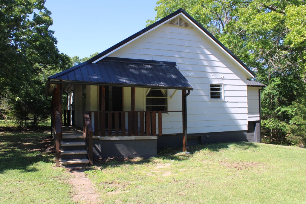 Very Near Bull Shoals Lake - enjoy the partial wrap-around porch, large living room, kitchen-dine combo, and large primary bedroom. Property includes 2 near level lots only a few minutes to Bull Shoals Lake known for water sports and fishing. Home has new metal roof installed in 2025, newer central heat & air units, and several other updates, continue updates to buyers preference. Full basement includes one car garage and offers lots of storage along with easy access to plumbing, etc, basement does have seepage in rainfall time but sump pump and de-humidifier removes moisture in short time. Two nice lots with 10 x 13 storage building, lots of shade trees and privacy, only a few minutes to Corp of Engineers maintained park and marina on Lake Bull Shoals. Seller has two extra lots available that join on the west side of this property for additional $4,500. Come See Soon!!