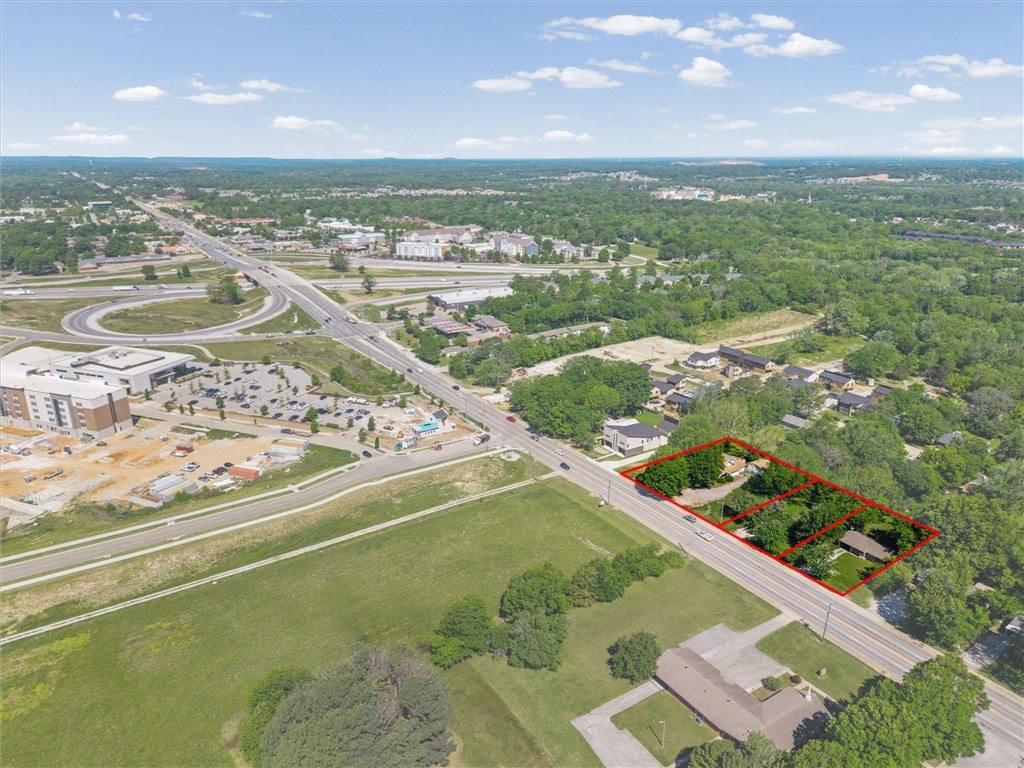 Prime development and investment opportunity located in one of Fayetteville’s fastest-growing corridors just off the I-49 Wedington exit. Positioned on high-traffic West Wedington Drive with excellent visibility and access, this property is ideal for future commercial development including QSRs, retail, office, bank branches, or mixed-use concepts. Conveniently located near Harps Grocery, shopping, dining, trail systems, and the University of Arkansas campus. The property includes a centrally located 3-bedroom, 1-bath home offering potential for rental income or interim use during future development. Surrounding area features a strong mix of single-family and multi-family housing in a high-demand growth corridor known for walkability and convenience. Zoned within the Fayetteville School District including Asbell Elementary, Holt Middle School, and Woodland Junior High. Rare opportunity with exceptional frontage, accessibility, and long-term potential in a rapidly developing area. Ref MLS 1347928, 1347918, 1347923