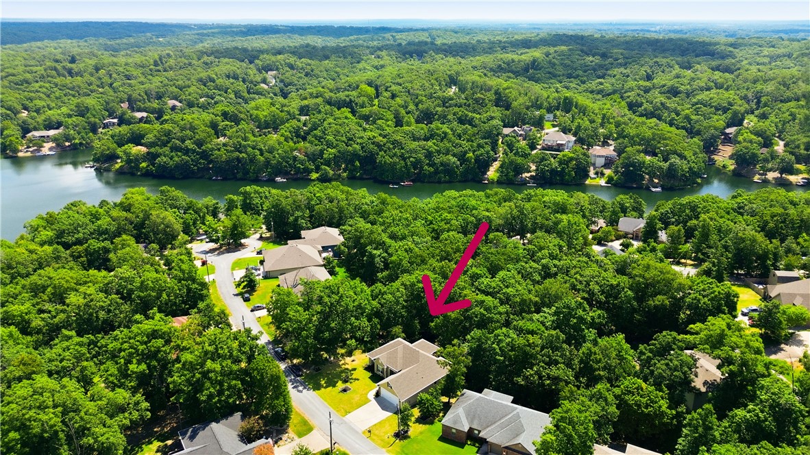Beautifully appointed, move-in ready home in the heart of Bella Vista! The open-concept layout features a spacious kitchen with a large island overlooking the dining and living areas, perfect for entertaining. Relax on the expansive covered deck with peaceful wooded surroundings and a seasonal view of Lake Brittany. A Galaxy lift "elevator" provides easy access between the upper and lower decks making accessibility barrier- free. The reinforced concrete patio is hot tub ready with electrical and water already in place. Additional upgrades include custom power window shades, gas log fireplace with remote and LeafGuard gutters with a transferable warranty. Freshly painted interior and stained/sealed deck. Bed swing and refrigerator convey. Just minutes from Lake Brittany, the Back 40 trail system, golf courses, lakes, recreationcenters, tennis, pickleball, hiking, and biking.Enjoy the perfect combination of modern comfort, thoughtful upgrades, and Bella Vista's outdoor lifestyle.