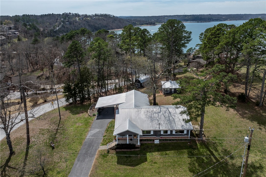 Enjoy Beaver Lake views from this charming 3 bedroom, 3 bath home offering 2,088 sq ft of versatile living on a combined .68 acre lot. Two generously sized bedrooms feature ensuite baths, creating comfort and privacy for guests or multi generational living. A flexible bonus room adds options for a second living area, game room, or media space. A separate detached building expands the possibilities as a home office, hobby room, or art studio, plus an additional storage shed for tools and lake gear. Start the day on the brand new deck and take in peaceful lake views and quiet mornings. Located just minutes from Prairie Creek Marina, Highway 12 boat ramp, Downtown Rogers and bike trails. This property combines everyday comfort with easy access to boating, fishing, and outdoor recreation