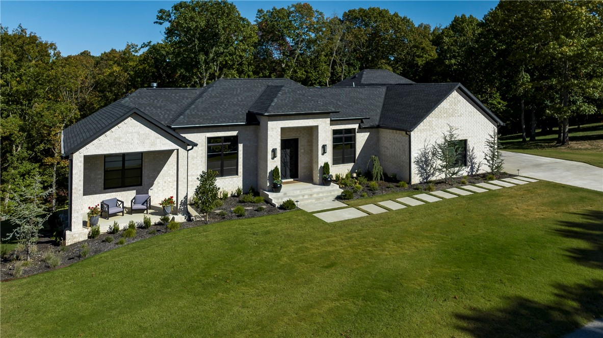 Peaceful sounds of rustling trees and chirping birds will be all you hear sitting outside on one of the patios or deck areas of this stunning custom build. Luxurious estate home with the cozy feel of country living.
Every high end detail so well thought out. Gas light sconces and double iron doors invite you into this gorgeous one of a kind home. Open floor plan with an amazing wooded view from inside. 2 bedrooms on each level.  (1) 35' RV/boat garage with hookups. (2) car garage is oversized and there is (1) utility garage downstairs.  Game / theater room downstairs with wet bar, home gym, yoga or storage room. Primary suite closet access to the laundry room. Walk in panty off of the kitchen. Multi room audio, surround sound, programable Lennox thermostats for precise control. Extensive security system. The upgrades are numerous. See amenities sheet for more! This wooded estate is minutes to Prairie Creek, downtown Rogers and shopping.